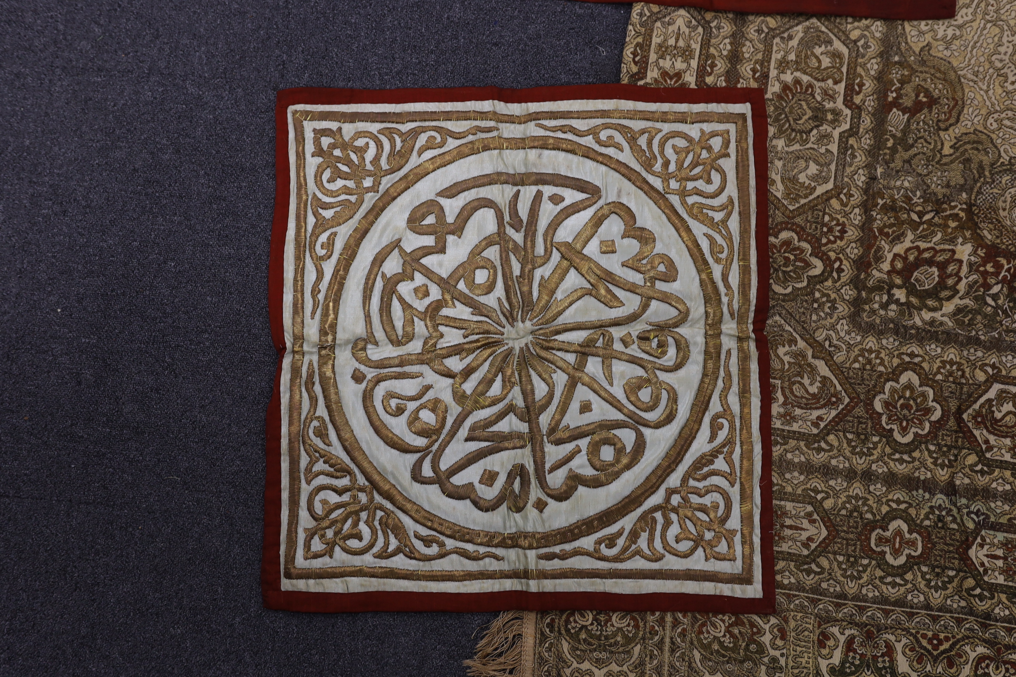Two 19th century Indian heavy metallic thread embroideries on silk, another smaller similar panel and later 20th century machine woven fringed bedcover, two metal embroideries 53cm x 52cm